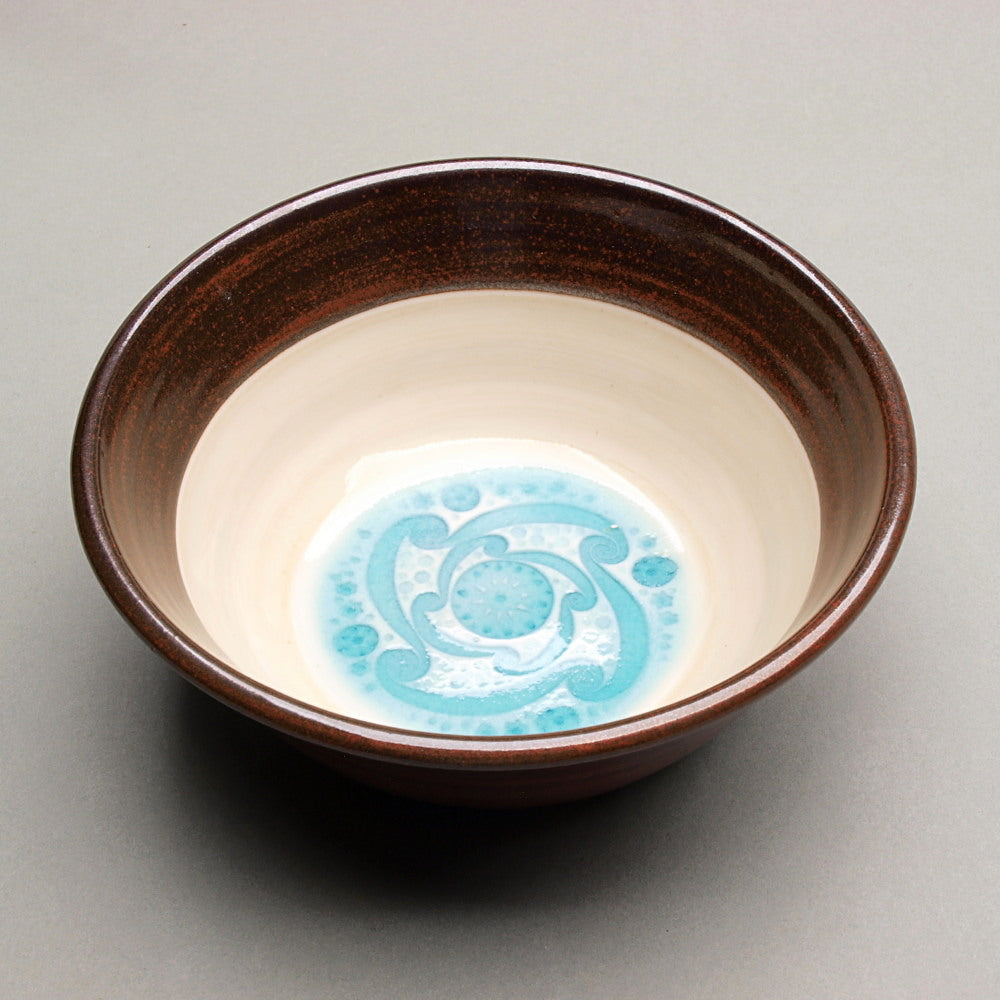 Porcelain Ceramic Bowl with a whirlwind motif imprint, and red-brown exterior. 6.5" dia. 2.5" tall