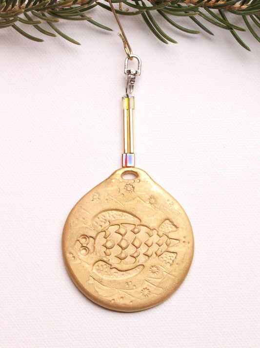 A ceramic collectable tree ornament with a golden turtle pattern. @ 1.9in dia., .15in thick